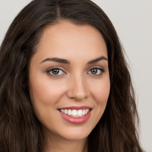 Joyful white young-adult female with long  brown hair and brown eyes