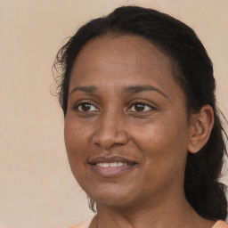 Joyful black adult female with medium  brown hair and brown eyes