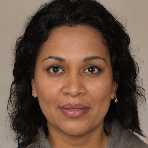 Joyful black adult female with medium  brown hair and brown eyes