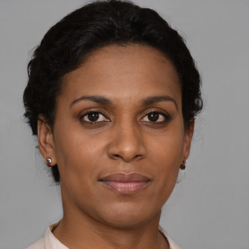 Joyful black adult female with short  brown hair and brown eyes