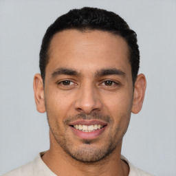 Joyful latino young-adult male with short  black hair and brown eyes