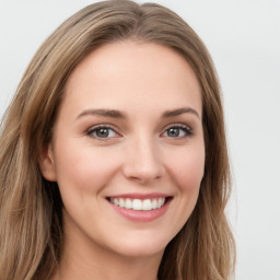 Joyful white young-adult female with long  brown hair and green eyes