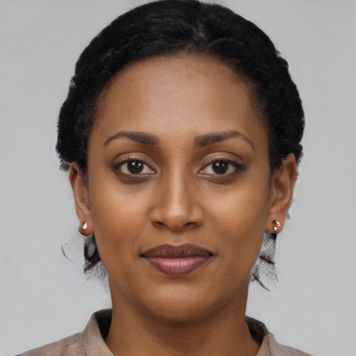 Joyful black young-adult female with short  black hair and brown eyes