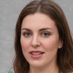 Joyful white young-adult female with long  brown hair and green eyes