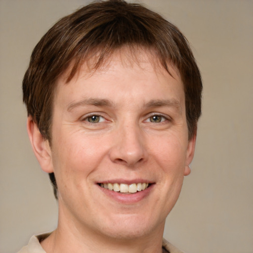 Joyful white adult male with short  brown hair and grey eyes