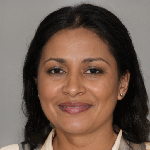 Joyful latino adult female with medium  brown hair and brown eyes