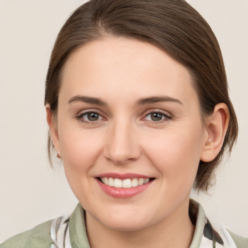 Joyful white young-adult female with medium  brown hair and grey eyes