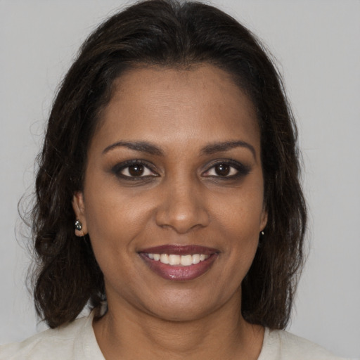 Joyful black young-adult female with medium  brown hair and brown eyes