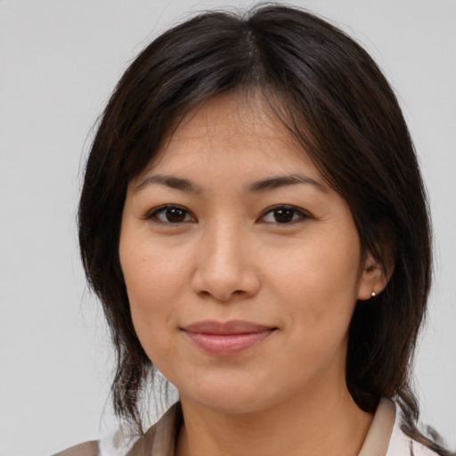 Joyful latino young-adult female with medium  brown hair and brown eyes