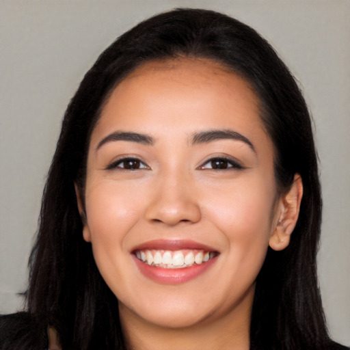 Joyful latino young-adult female with long  black hair and brown eyes