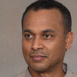 Joyful black adult male with short  black hair and brown eyes