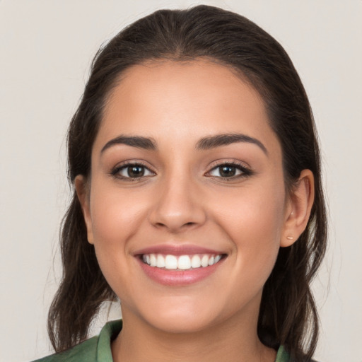 Joyful white young-adult female with long  brown hair and brown eyes