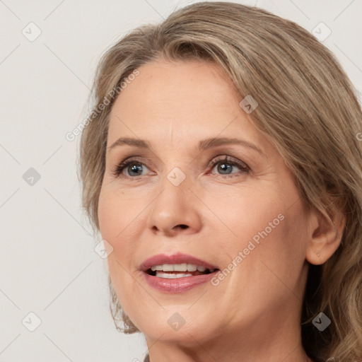 Joyful white adult female with medium  brown hair and grey eyes