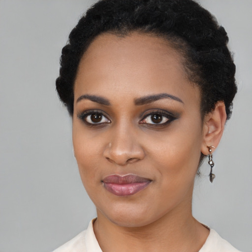 Joyful black young-adult female with short  black hair and brown eyes