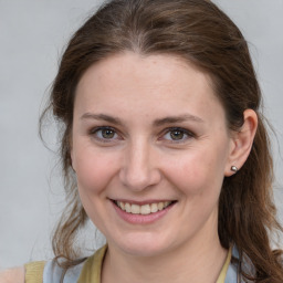 Joyful white young-adult female with medium  brown hair and grey eyes