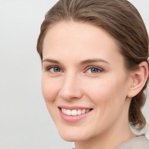 Joyful white young-adult female with medium  brown hair and grey eyes