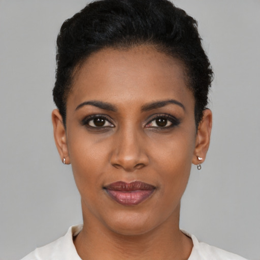 Joyful black young-adult female with short  black hair and brown eyes
