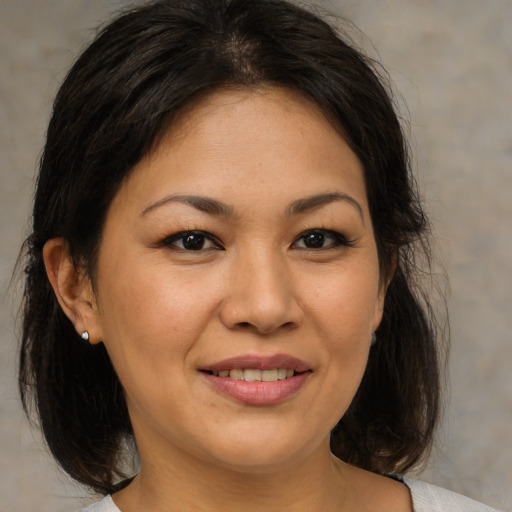Joyful asian adult female with medium  brown hair and brown eyes