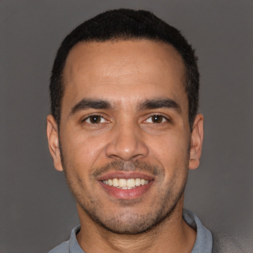 Joyful latino young-adult male with short  black hair and brown eyes