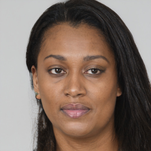 Joyful black adult female with long  brown hair and brown eyes