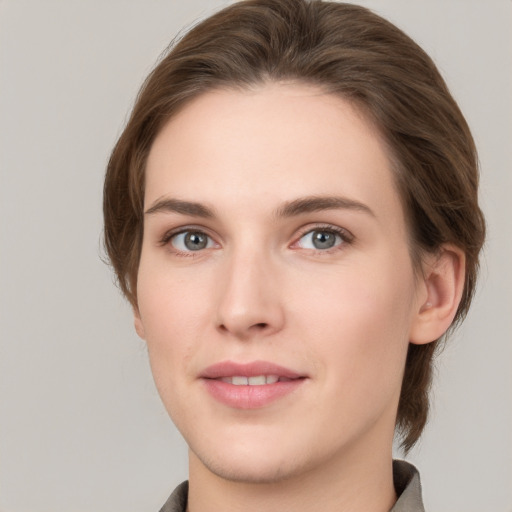 Joyful white young-adult female with medium  brown hair and grey eyes