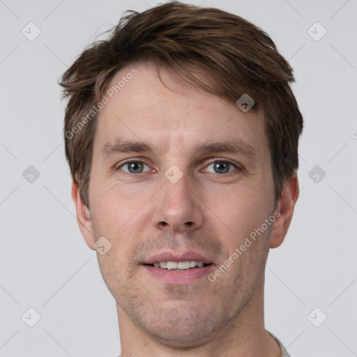 Joyful white adult male with short  brown hair and grey eyes