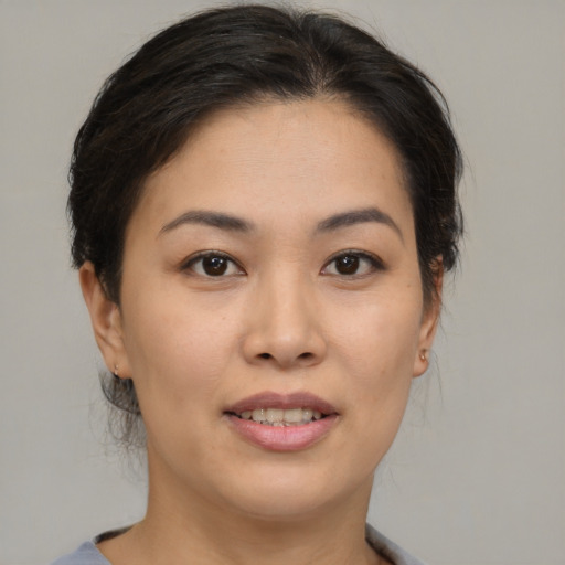 Joyful asian young-adult female with medium  brown hair and brown eyes