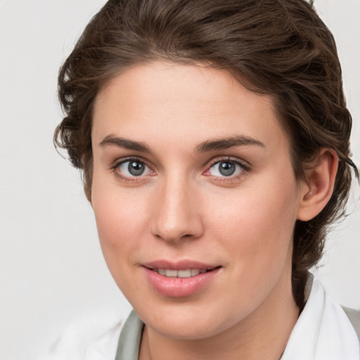 Joyful white young-adult female with medium  brown hair and green eyes