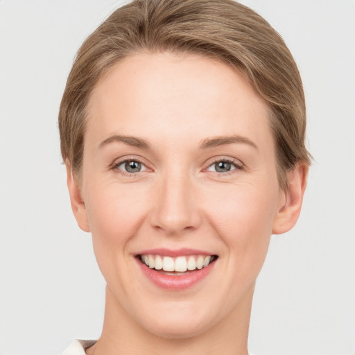 Joyful white young-adult female with short  brown hair and grey eyes