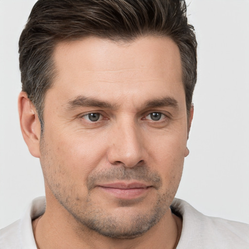 Joyful white adult male with short  brown hair and brown eyes