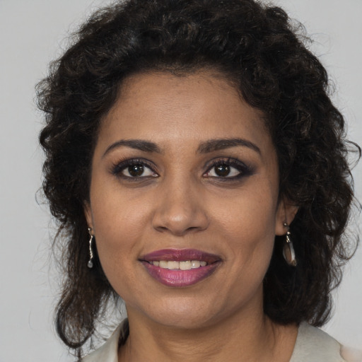 Joyful black adult female with long  brown hair and brown eyes