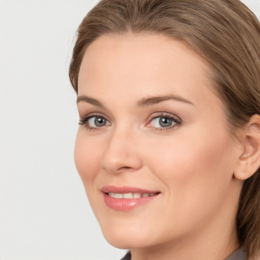 Joyful white young-adult female with long  brown hair and grey eyes