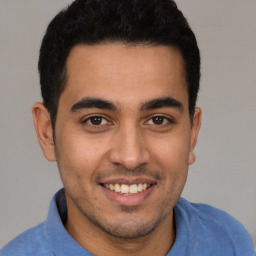 Joyful latino young-adult male with short  brown hair and brown eyes