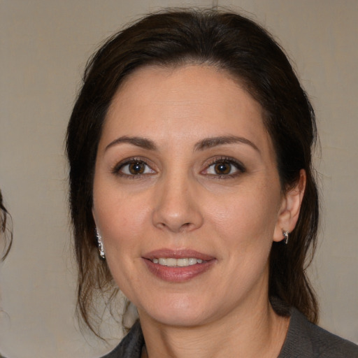 Joyful white adult female with medium  brown hair and brown eyes