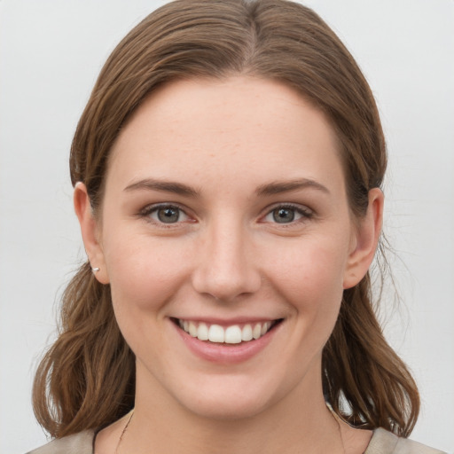 Joyful white young-adult female with medium  brown hair and grey eyes