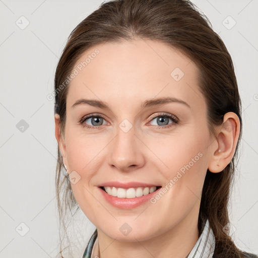 Joyful white young-adult female with long  brown hair and grey eyes