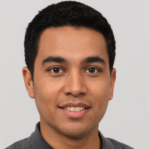 Joyful latino young-adult male with short  black hair and brown eyes