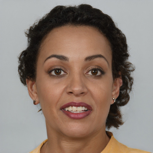 Joyful latino adult female with medium  brown hair and brown eyes