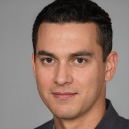 Joyful white young-adult male with short  black hair and brown eyes