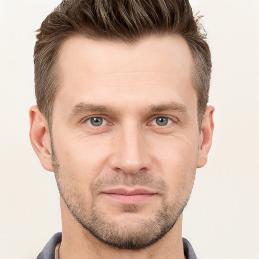 Joyful white young-adult male with short  brown hair and grey eyes