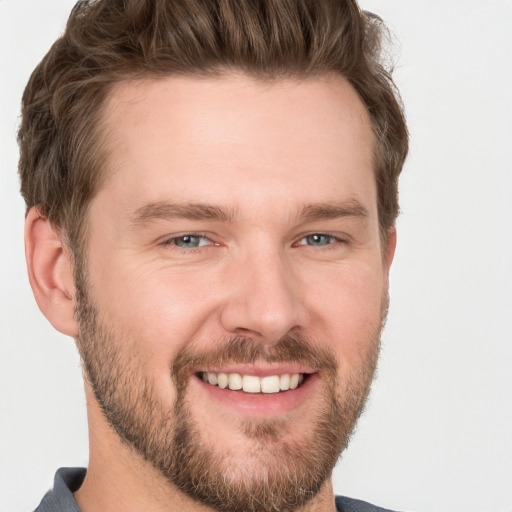 Joyful white young-adult male with short  brown hair and grey eyes