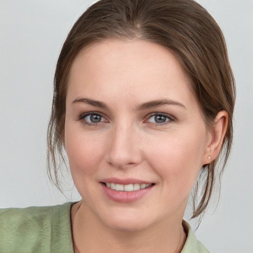 Joyful white young-adult female with medium  brown hair and grey eyes