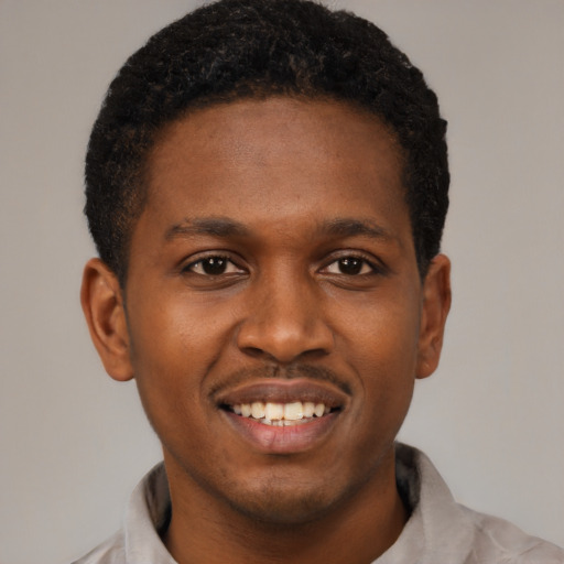 Joyful black young-adult male with short  brown hair and brown eyes