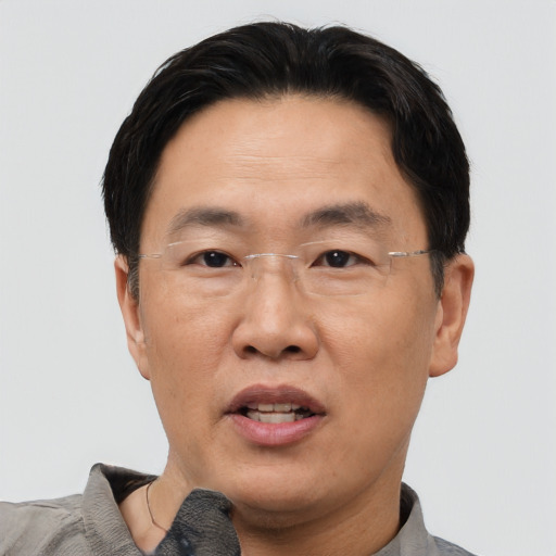 Joyful asian adult male with short  black hair and brown eyes