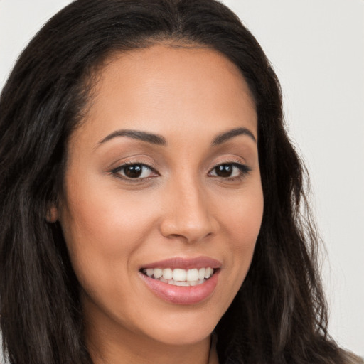 Joyful latino young-adult female with long  brown hair and brown eyes