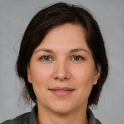 Joyful white adult female with medium  brown hair and grey eyes