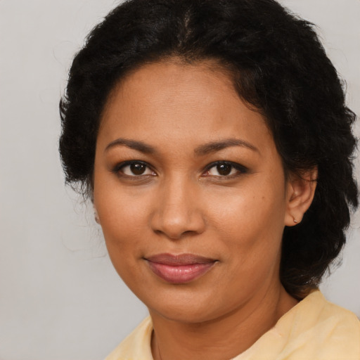 Joyful latino adult female with medium  brown hair and brown eyes