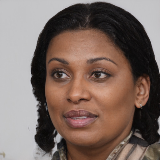 Joyful black adult female with medium  brown hair and brown eyes