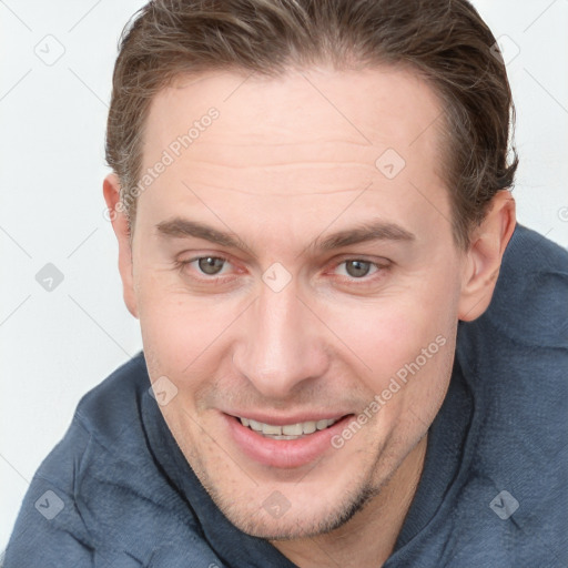 Joyful white young-adult male with short  brown hair and grey eyes