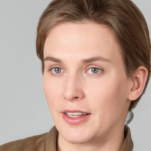 Joyful white young-adult female with short  brown hair and blue eyes